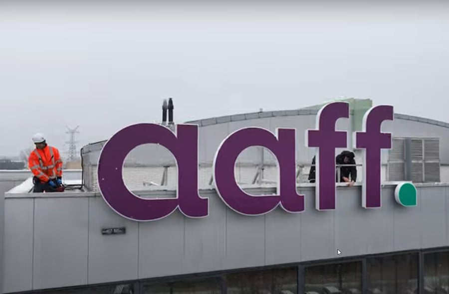 Het aaff-logo wordt op het dak van een kantoorpand gemonteerd.