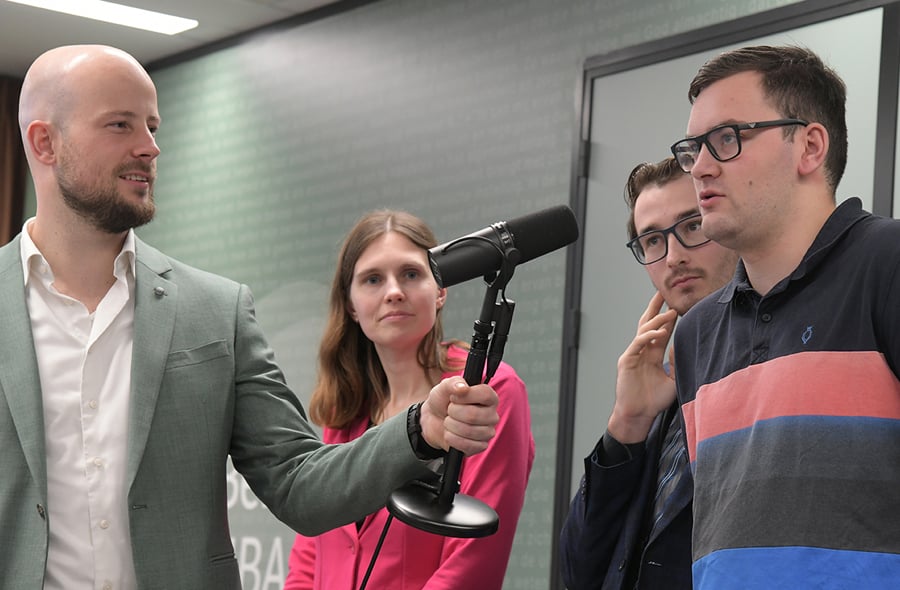 Jeffrey Heerschop met micorfoon bij deelnemers aan het verkiezingsdebat van de BusySeasonTalks bij de NBA in Hoofddorp