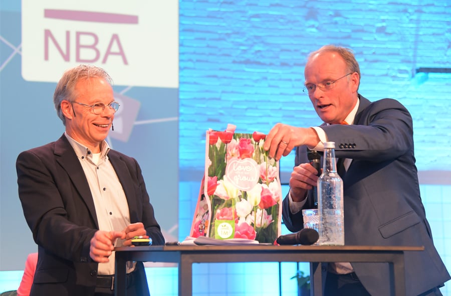 Kris Douma en Peter Paul de Vries op het podium tijdens de ledenvergadering op 11 december 2023