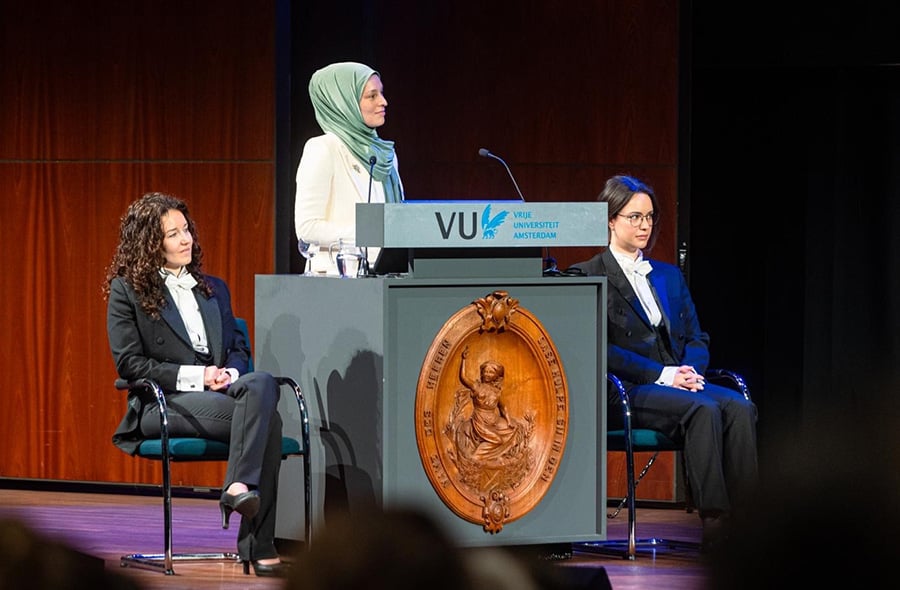 Wendy Groot op het podium tijdens de verdediging van haar proefschrift, geflankeerd door haar paranimfen